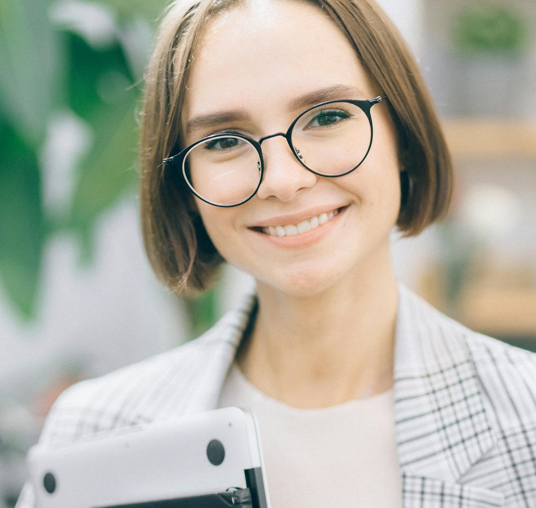 A Woman in Eyeglasses Carrying a Laptop